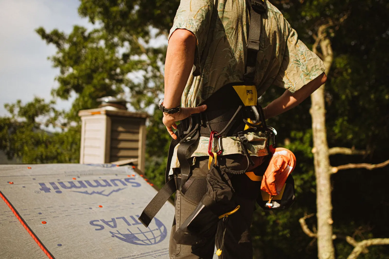 A loaded tool belt and hammer, worn and in use on a roofing job.
